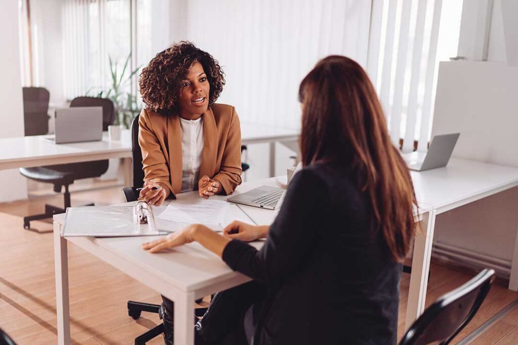 A person reviewing monthly bills and planning a household budget at a kitchen table.
